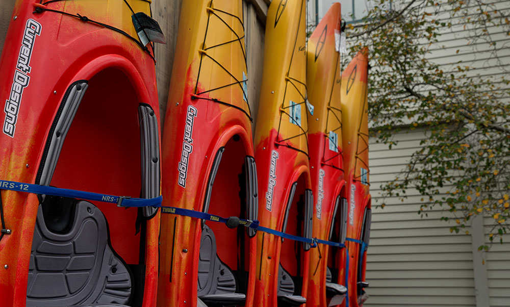 An image of a row of orange and yellow sea kayaks.